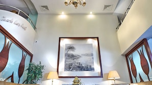 A lobby with a chandelier, two sofas, a coffee table, and a framed picture on the wall. - Feronya Hotel (Istanbul)