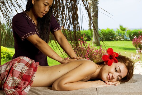 A person receiving a massage in a garden setting with a tropical backdrop. - Flora Garden Beach Club - All inclusive (Manavgat)