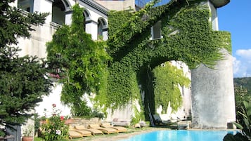 Una piscina al aire libre, sillones reclinables de piscina