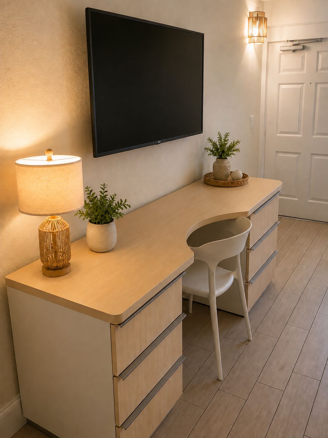 A modern kitchen with a flat-screen TV, a lamp, and a plant on the counter.