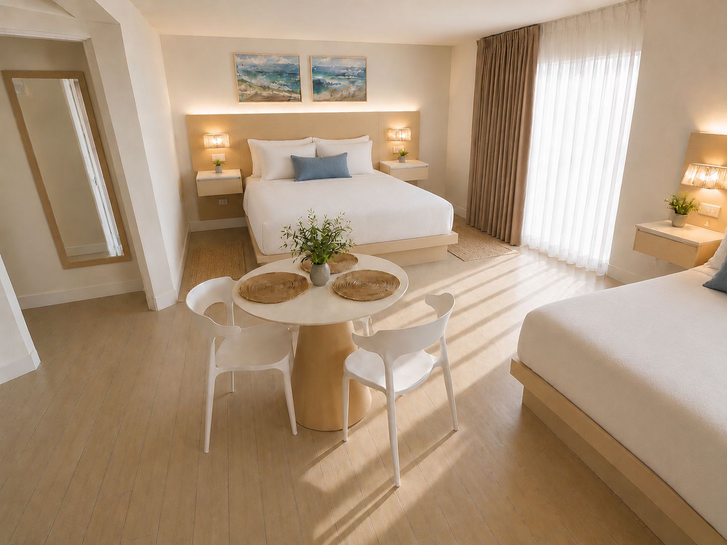 A hotel room with a bed, bedside tables, a round dining table with chairs, and artwork on the wall.