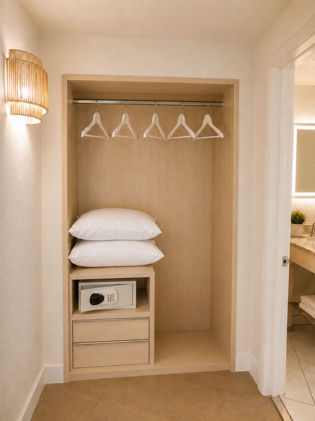 Un dressing avec une tringle à vêtements, un meuble de rangement avec des tiroirs et un luminaire.