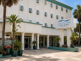 A hotel entrance with a sign reading 'Chateau Mar Beach Resort.'