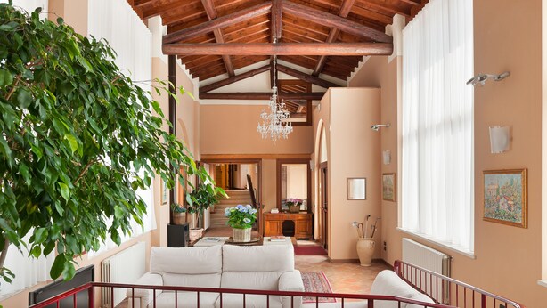 A spacious living area with a high ceiling, a staircase, and a large window. - Hotel Tre Punte (Gargnano)