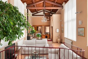 A spacious living area with a high ceiling, a staircase, and a large window. - Hotel Tre Punte (Gargnano)