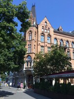 Un edificio histórico con una torre destacada y ventanas de arco.