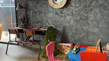 A child's play area with a desk, chairs, and toys.