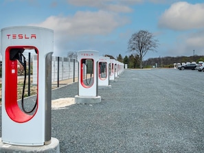 A row of Tesla electric vehicle charging stations in a parking lot. - Ibis Styles Vierzon (Vierzon)