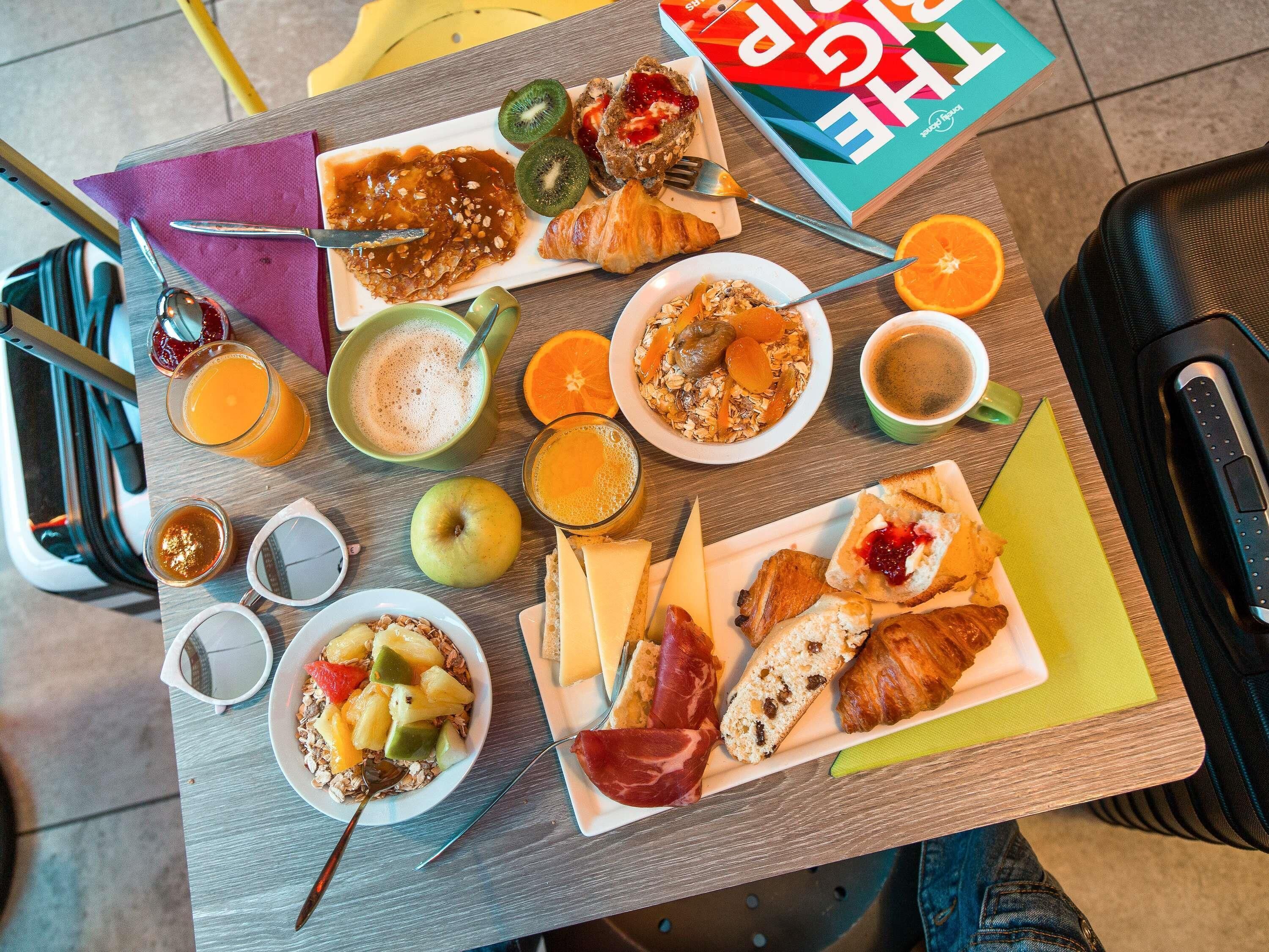 A breakfast buffet with various food items and a book on the table.