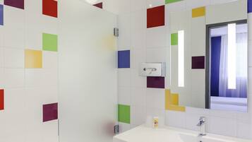 Ein modernes Badezimmer mit einer weißen Badewanne, einem weißen Waschbecken und einem Spiegel darüber.