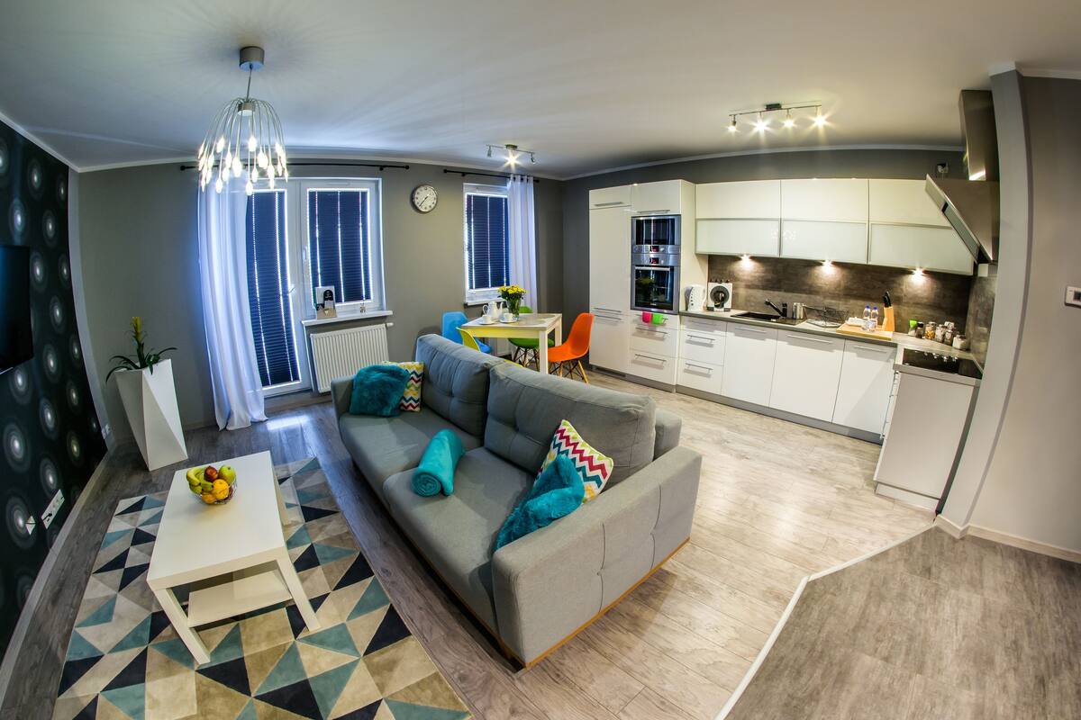 A modern apartment with a living room, dining area, and kitchen.
