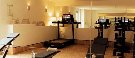 A gym with exercise equipment, a treadmill, and a bench.