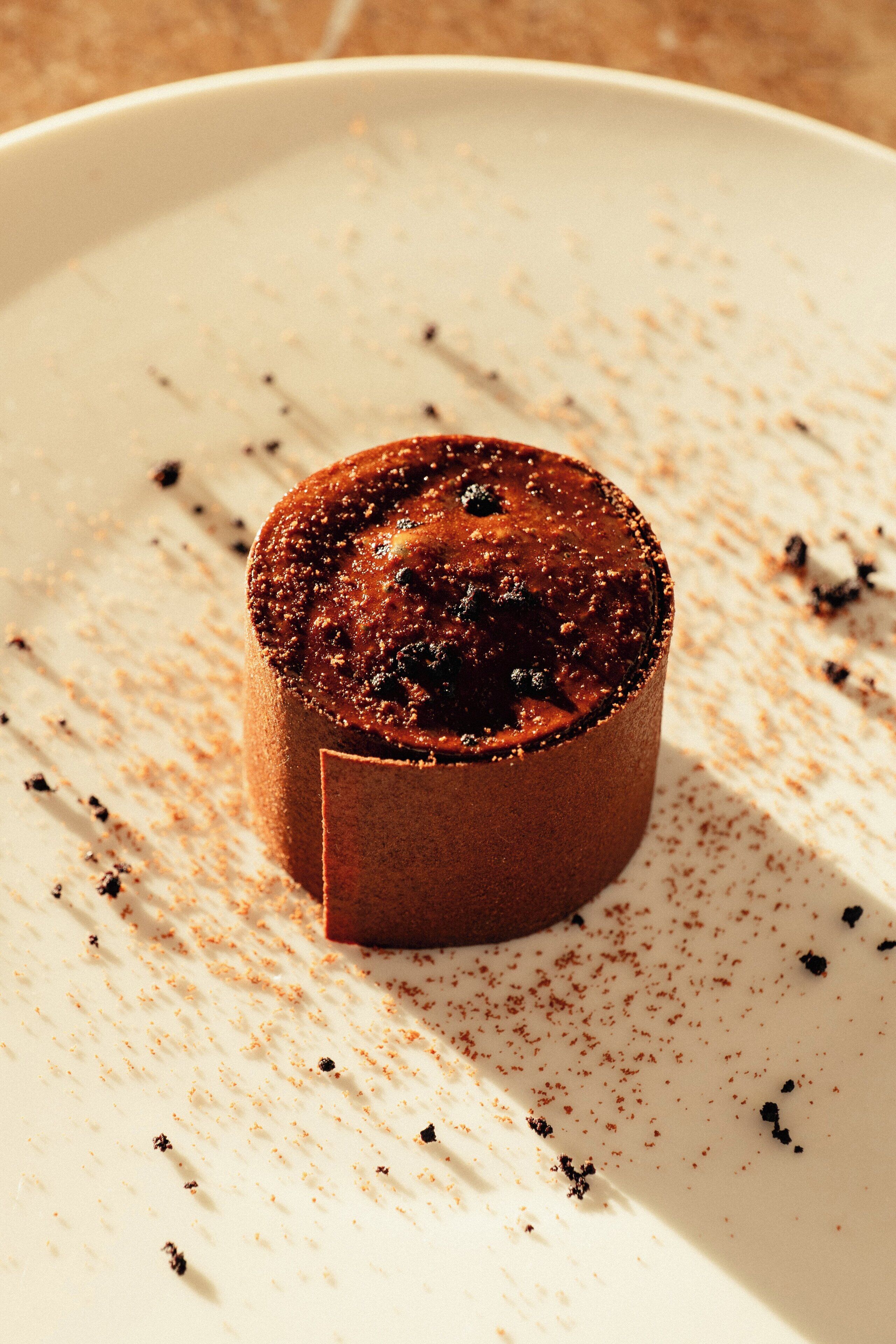 A dessert on a plate with a dusting of cocoa powder.
