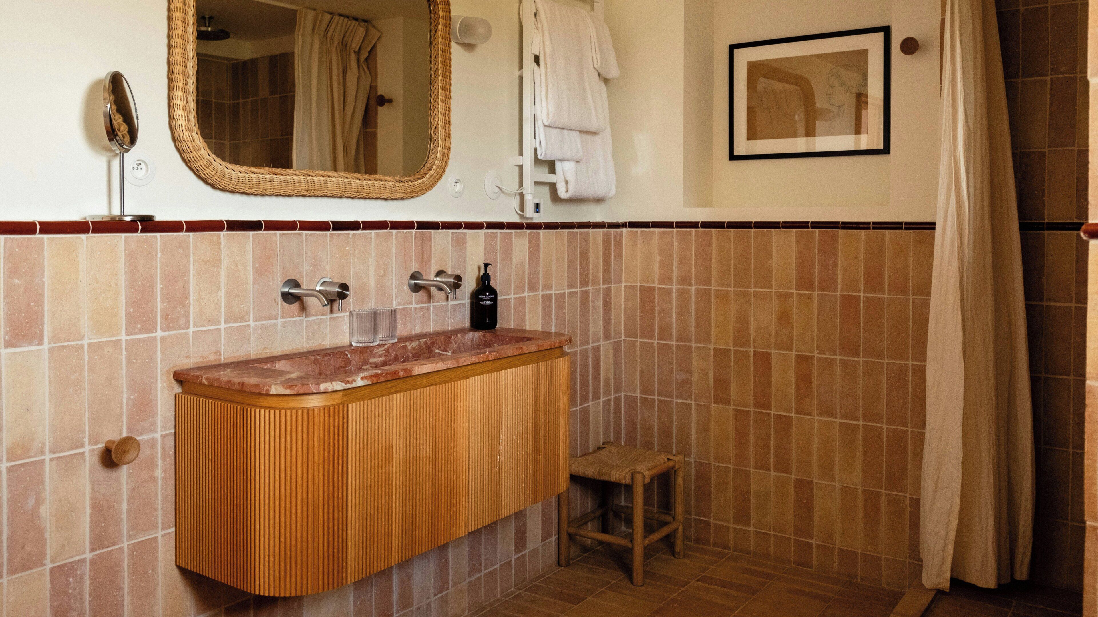 A bathroom with a wooden vanity, a mirror, a towel rack, and a framed picture on the wall.