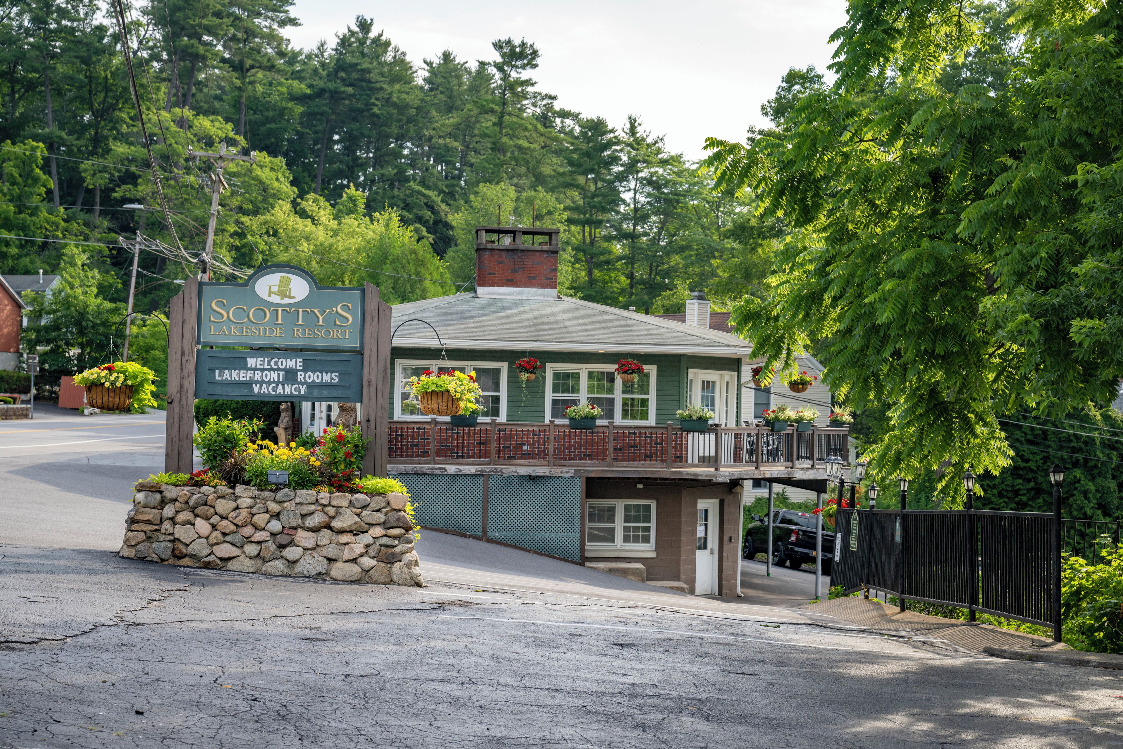 Un complexe hôtelier au bord du lac, avec un panneau indiquant « Scotty's Lakeside Resort » et « Chambres disponibles donnant sur le lac ».
