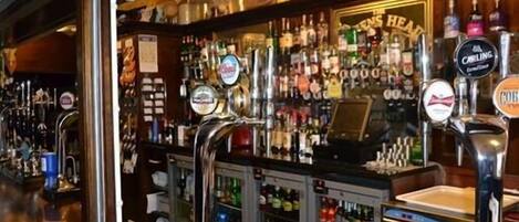 Een bar met verschillende biertaps en een ruime selectie drankflessen.