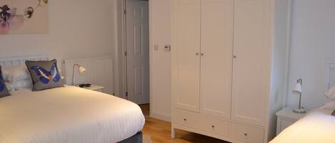 Ein Schlafzimmer mit einem großen Bett, einem Kleiderschrank und einem Nachttisch.