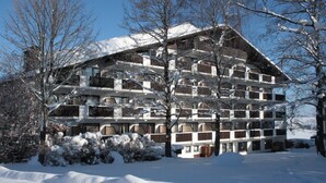 A multi-story hotel with balconies and a snow-covered landscape.