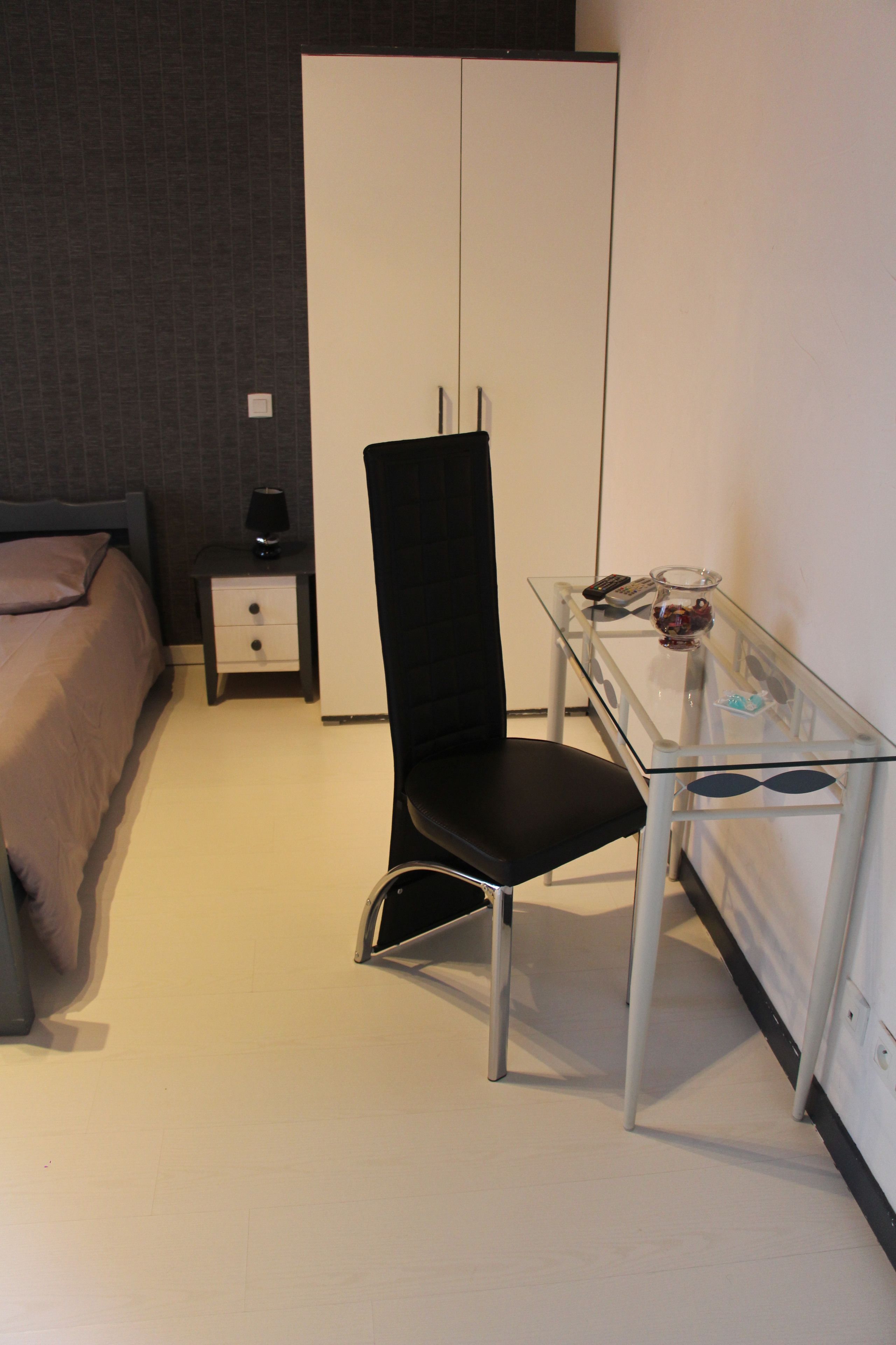 Une chambre à coucher avec un lit, une table de chevet, un bureau et une chaise.