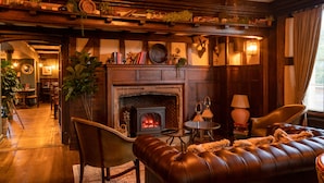 Una sala de estar acogedora con chimenea, sofá de cuero y muebles de madera.