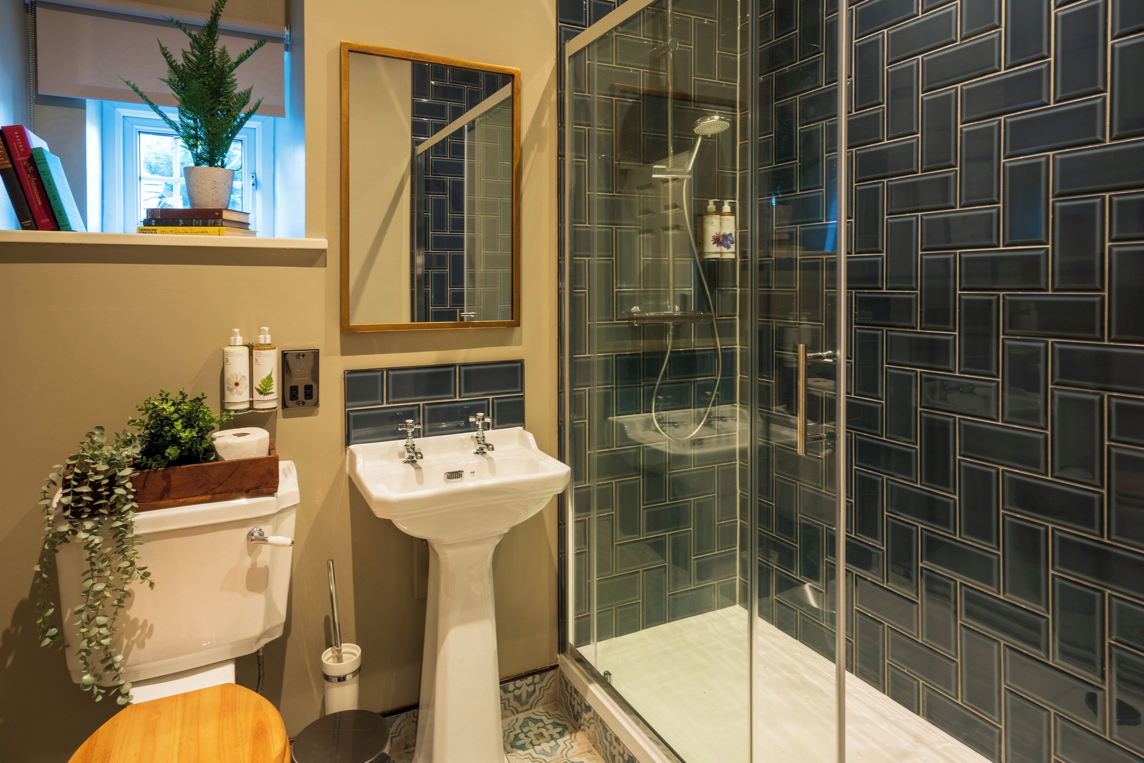 A bathroom with a toilet, sink, and glass-enclosed shower.
