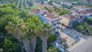 Vista aérea de una zona residencial con varias casas de dos pisos, un estacionamiento y palmeras.