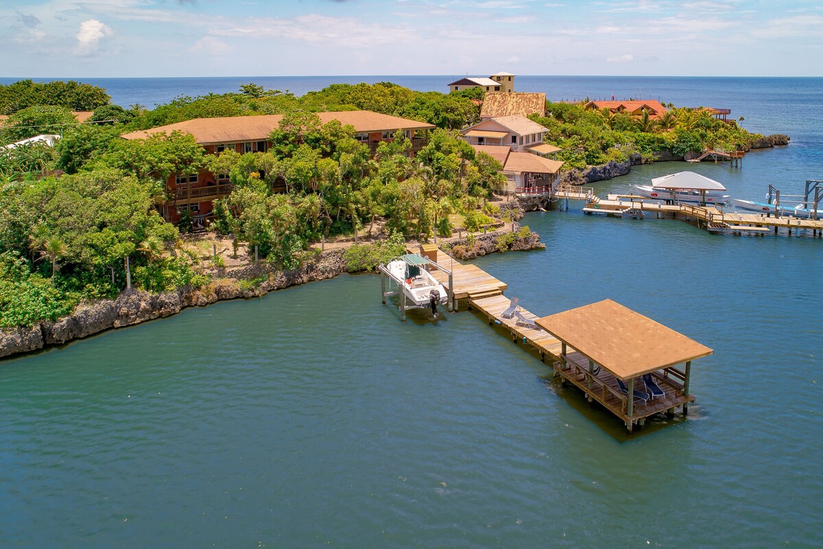 A coastal property with multiple buildings, a dock, and boats.