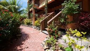 A hotel with a brick pathway leading to a wooden staircase.