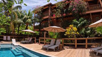Relax by the serene pool surrounded by lush greenery and comfortable lounge chairs.