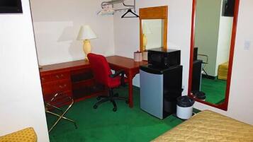 Una habitación pequeña y funcional con escritorio, silla y cama.