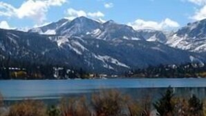 A mountain landscape with a lake and snow-capped peaks.