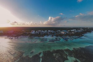 Vista aérea de una zona costera con aguas cristalinas, barcos y edificios.