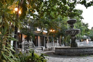 A courtyard with a fountain, benches, and lush greenery. - Hotel Posada Santa Fe (Zapopan)