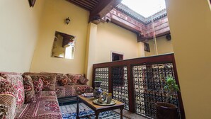 Una sala de estar tradicional con un sofá, una mesa de centro y una planta en maceta.