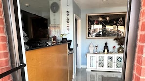 A modern kitchen with a wooden island, a black countertop, and a large window.