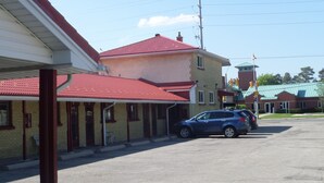 A building with a red roof and a small attached structure with a green roof. - Lakeridge Motel (Whitby)