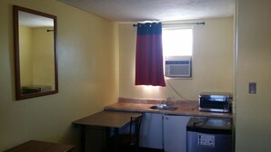 A compact kitchen with a microwave, sink, and small refrigerator. - Lakeridge Motel (Whitby)