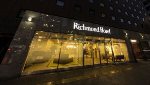The exterior of the Richmond Hotel with a glass facade and illuminated signage. - Richmond Hotel Hakataekimae (Fukuoka)