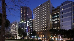 A modern hotel with multiple floors, large windows, and a prominent entrance. - Keio Presso Inn Ikebukuro (Tokyo)