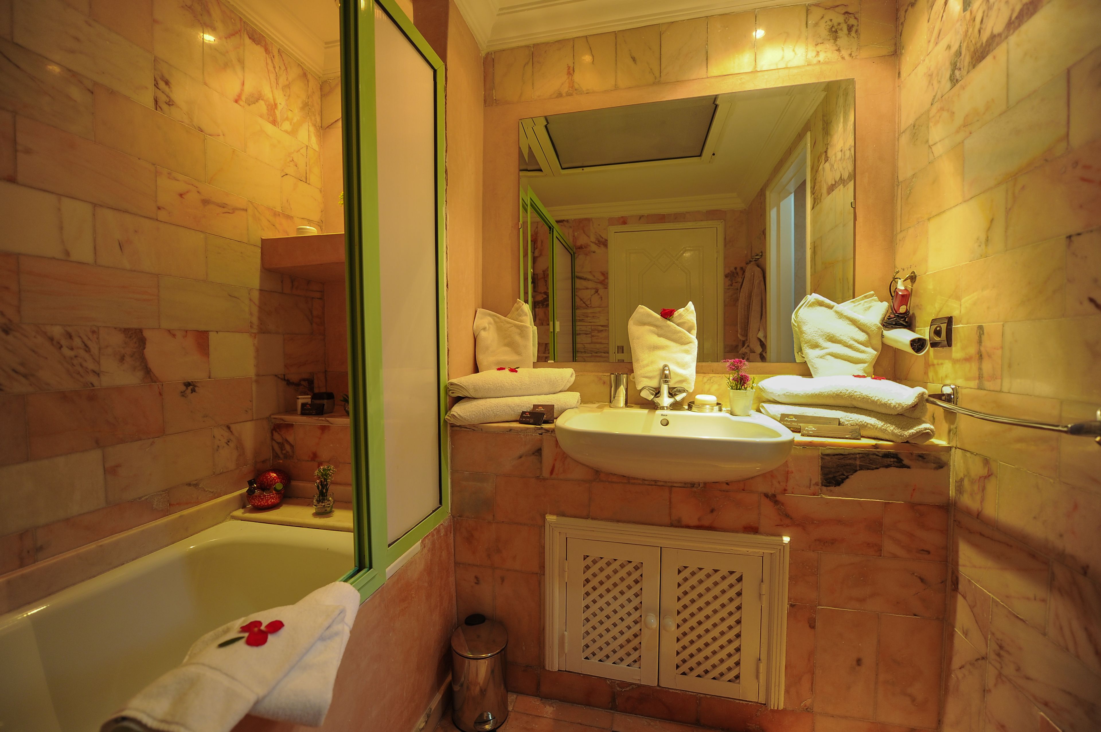 A bathroom with a bathtub, sink, and mirror.