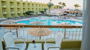 A hotel pool area with multiple lounge chairs, umbrellas, and a view of the ocean. - Eurotel Palm Beach Resort (Hurghada)