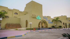 A Palm Beach Resort building with a large entrance, palm trees, and a staircase leading up to the entrance. - Eurotel Palm Beach Resort (Hurghada)
