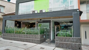 A modern building with a green facade, large windows, and a sign reading "Volare". - Hotel Volare (Armenia)