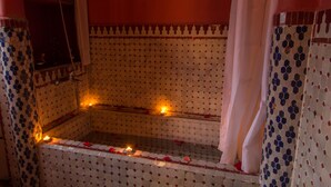 A bathroom with a tiled floor, a shower area, and a mirror. - Riad El Bacha (Fes)