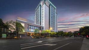 A modern hotel with a prominent vertical design, multiple floors, and a well-lit entrance. - Hangzhou Wassim Resorts Hotel  (Hangzhou)