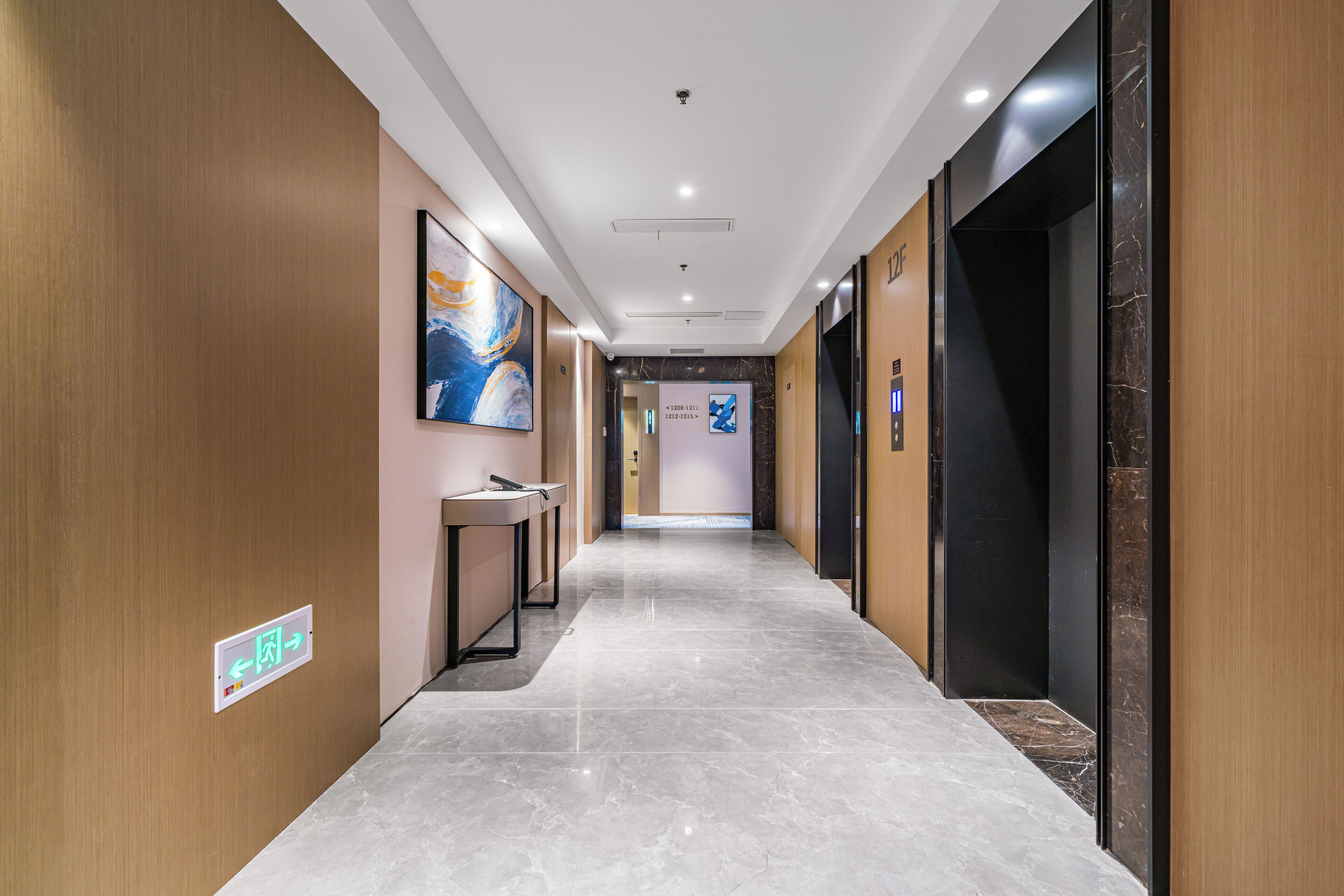 Un couloir d’hôtel moderne avec un sol en marbre, des murs en bois et un comptoir de réception.