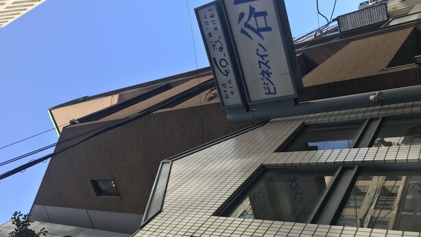 Ein Gebäude mit einer Kachelfassade und einem Schild mit japanischen Schriftzeichen.