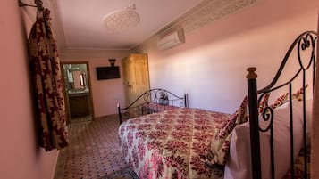 Une chambre à coucher avec un lit, une armoire et un téléviseur fixé au mur.