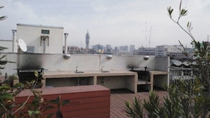 A rooftop terrace with a built-in sink and a satellite dish. - Amistar Plaza París (Santiago)