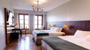 A hotel room with two beds, a desk, a chair, and a TV. - Wyndham Garden Luján (Luján)
